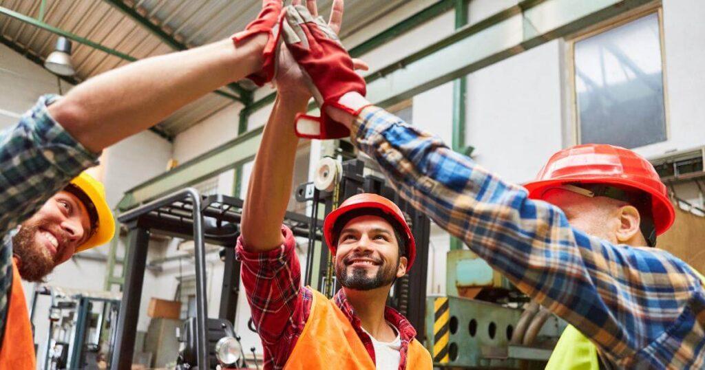 three industrial workers high fiving