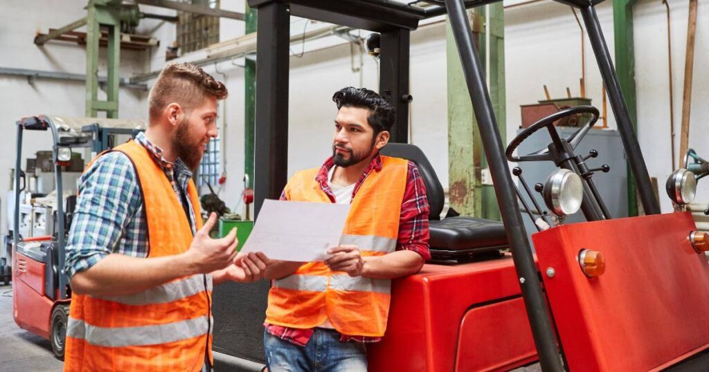 two forklift drivers discussing work