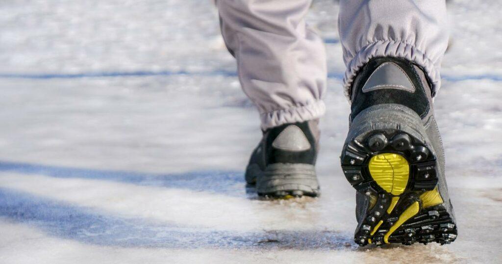 person walking on slippery sidewalk with proper footwear winter weather