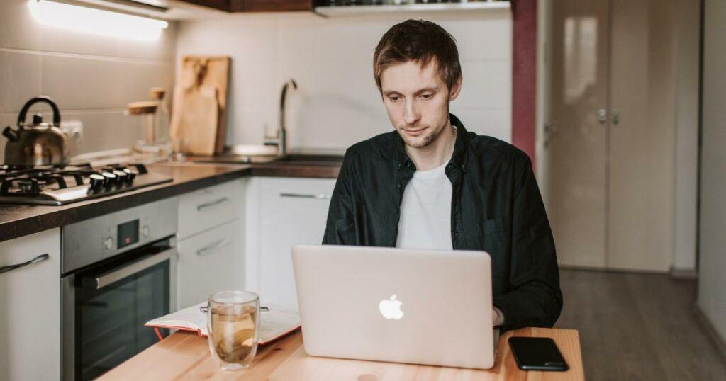 man looking at laptop for job search