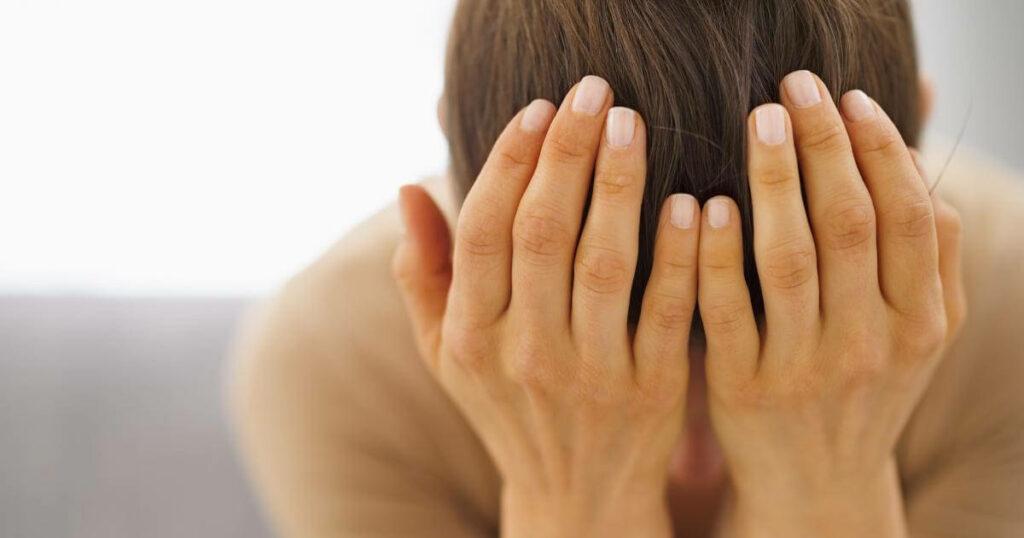 stressed woman with head in hands