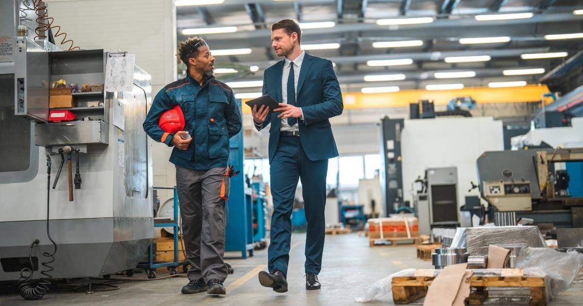 manager and employee walking together in manufacturing plant